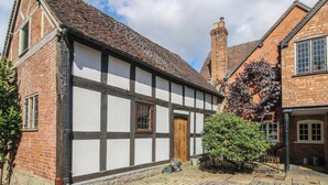 A traditional half-timbered house with a brick facade and white timber framing.