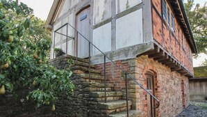 A historic building with a stone staircase leading to a wooden door marked "Office". - The Coach House (Church Stretton)