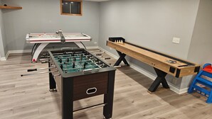 A room with a foosball table, a pool table, and a shuffleboard table. - Fun 5BR 4.5BA, Pool, Hot Tub, Game Rm, Near O’Hare (Wood Dale)
