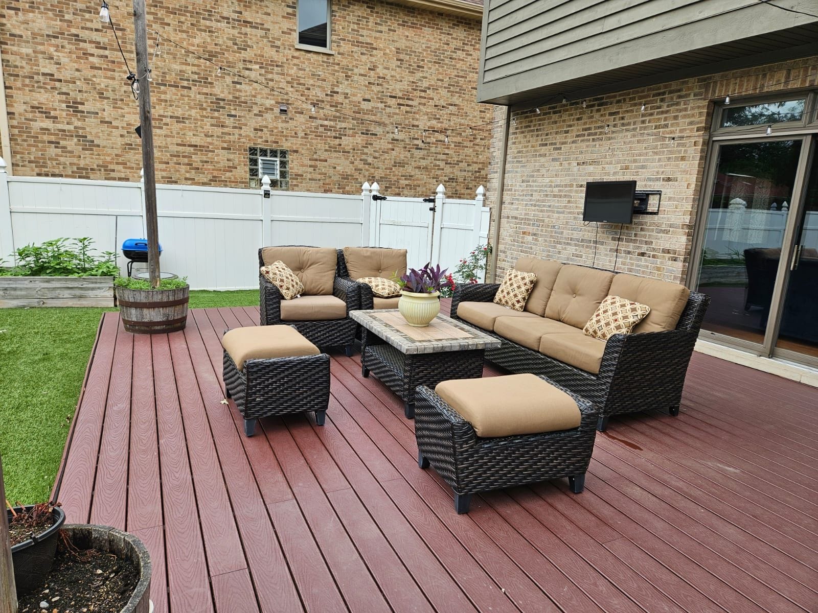 Une terrasse extérieure avec des meubles en osier, une table et une plante en pot.