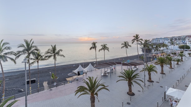 A coastal promenade with palm trees, a beach, and buildings in the background. - Studio 'Martin - 23' with Sea View, Balcony and Wi-Fi (Puerto de Naos)