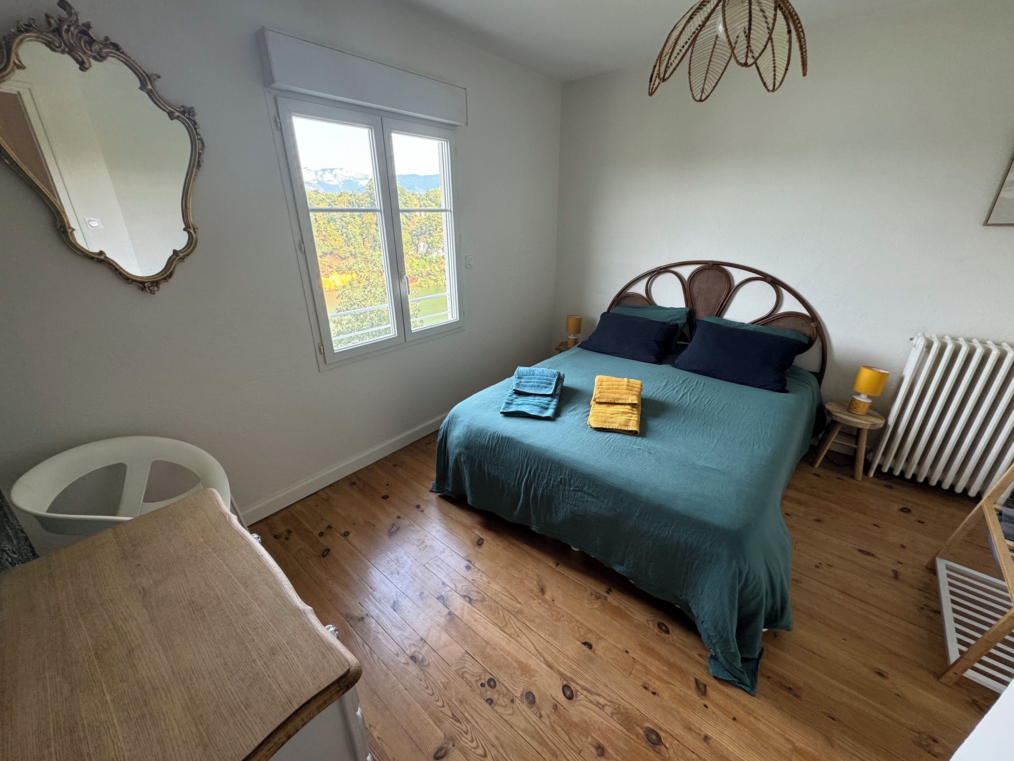 Une chambre à coucher avec un lit, une fenêtre, un radiateur et une chaise.