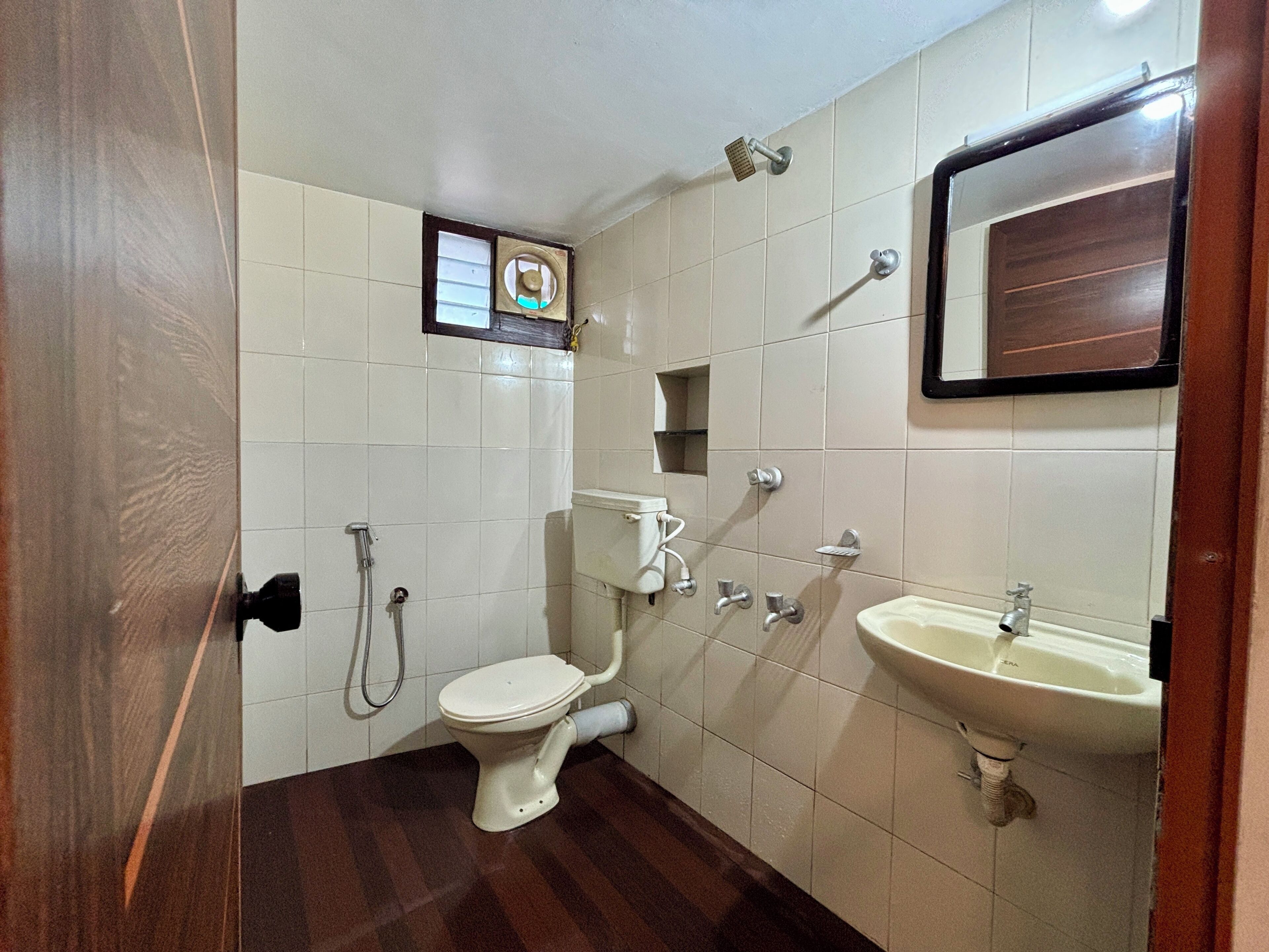 A small bathroom with a toilet, a shower, and a sink.