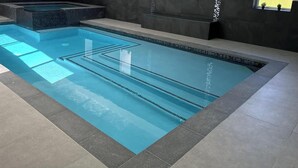 A modern indoor swimming pool with clear lanes, a hot tub, and a tiled floor. - Newly Built Luxury Chalet Indoor Pool Ski Lift (The Blue Mountains)