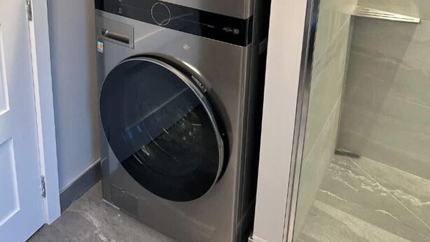 A compact, stainless steel wall-mounted washer and dryer unit with a control panel and a small storage compartment. - Newly Built Luxury Chalet Indoor Pool Ski Lift (The Blue Mountains)