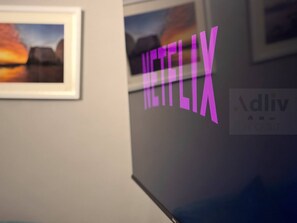 A wall with the Netflix logo and a sign that reads "dliv host". - Coastal Home Away From Home by Adliv (Broadstairs)