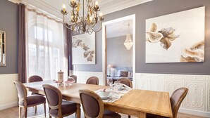 Een eetkamer met een houten tafel voor zes personen, omringd door gestoffeerde stoelen.