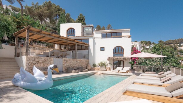 A swimming pool with lounge chairs, a swan float, and a covered patio area. - Can Furnet in Ibiza With 4 Bedrooms and 8 Bathrooms (Santa Eulalia del Rio)