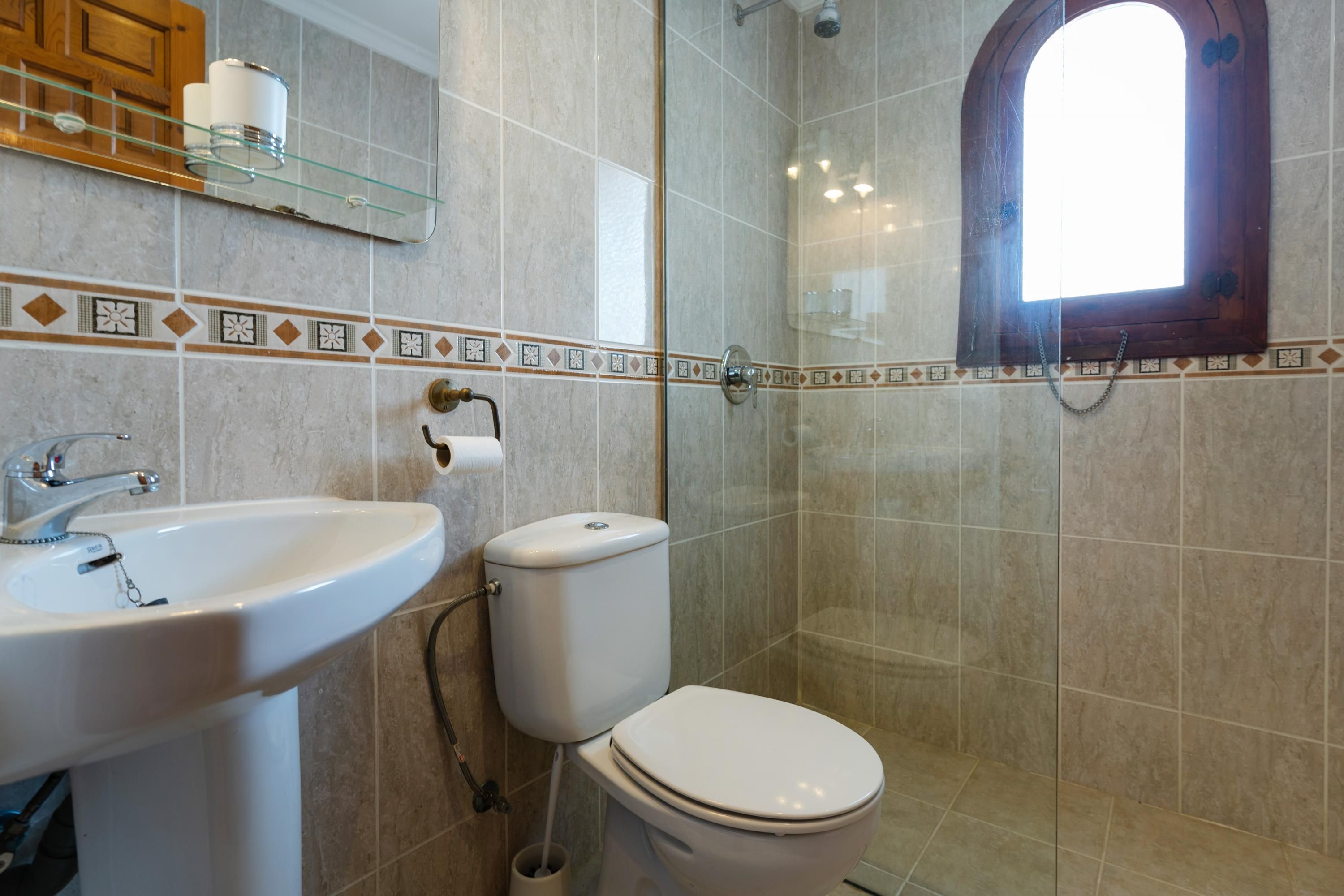 A bathroom with a sink, toilet, and shower.
