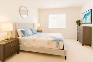 Un dormitorio con cama, mesitas de noche, cómoda, espejo y ventana.