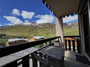 A balcony with a view of snow-capped mountains and a clear blue sky. - 150m from ski slopes, floor -4, view ski slopes, balcony, tv, 28m², Les Menuires (Les Menuires)