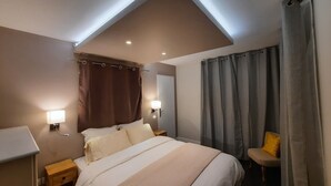 A hotel room with a bed, bedside lamps, a nightstand, a chair, and a window with curtains. - The magnolia (Hautot-sur-Mer)