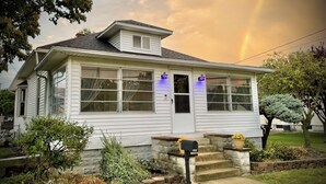 A white two-story house with a front porch, stone steps, and a mailbox. - *Port Clinton*3 BedRM*SunRM*Fenced Yard*Near Beach/Park/Lighthouse/Restaurants* (Port Clinton)