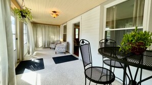 A room with a dining table, chairs, a hanging plant, and a window with curtains. - *Port Clinton*3 BedRM*SunRM*Fenced Yard*Near Beach/Park/Lighthouse/Restaurants* (Port Clinton)