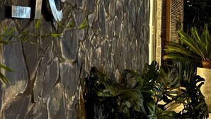 Un edificio con fachada de piedra y un gran letrero de metal que dice "UKO".