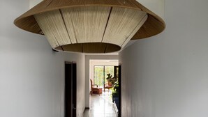 Un pasillo con una lámpara de techo grande de fibra y baldosas de piso estampadas.