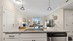 A modern kitchen with granite countertops, a stainless steel dishwasher, and pendant lighting. - Powell Retreat Attached Garage Walk-in Shower (Powell)