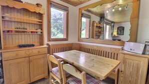 Una cocina acogedora con armarios de madera, una mesa de comedor y un banco.