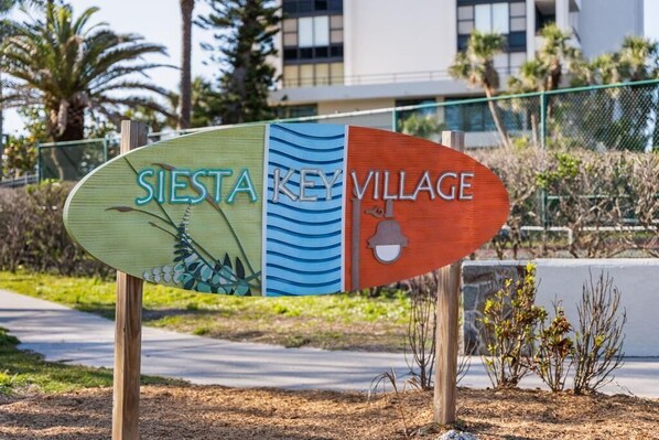 A sign with the text 'SIESTA KEY VILLAGE' indicating the name of the location.