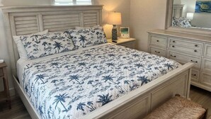 Ein Schlafzimmer mit Bett, Nachttischen, Kommode und Spiegel.