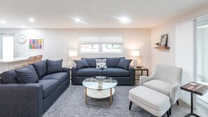 A modern living room with a grey sofa set, a glass coffee table, and a light grey armchair. - Csa Blanca - Villa B18 (Sarasota)