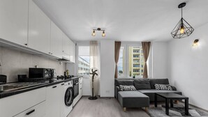 Un apartamento moderno con cocina, sala de estar y vista a un edificio.