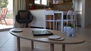 Een moderne keuken met een eetgedeelte, met een ronde tafel, een spel, stoelen en een decoratief olifantje.