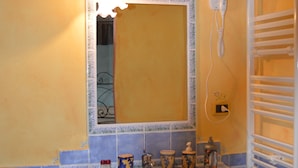 A bathroom with a sink, mirror, and towel rack.