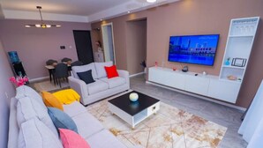 A modern living room with a sofa, coffee table, and TV. - Lymack Suites, 1BR Fourways Junction , Kiambu Road (Nairobi)