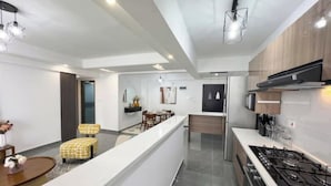 A modern kitchen with a central island, stainless steel appliances, and wooden cabinets.