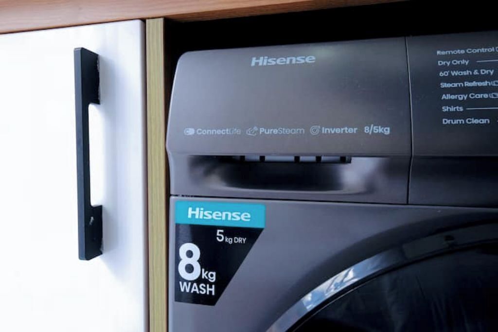 Een Hisense wasmachine met een label waarop staat dat deze 5 kg droog en 8 kg wasgoed aankan.