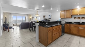 A spacious kitchen with wooden cabinets, a central island, and a dining area with chairs.