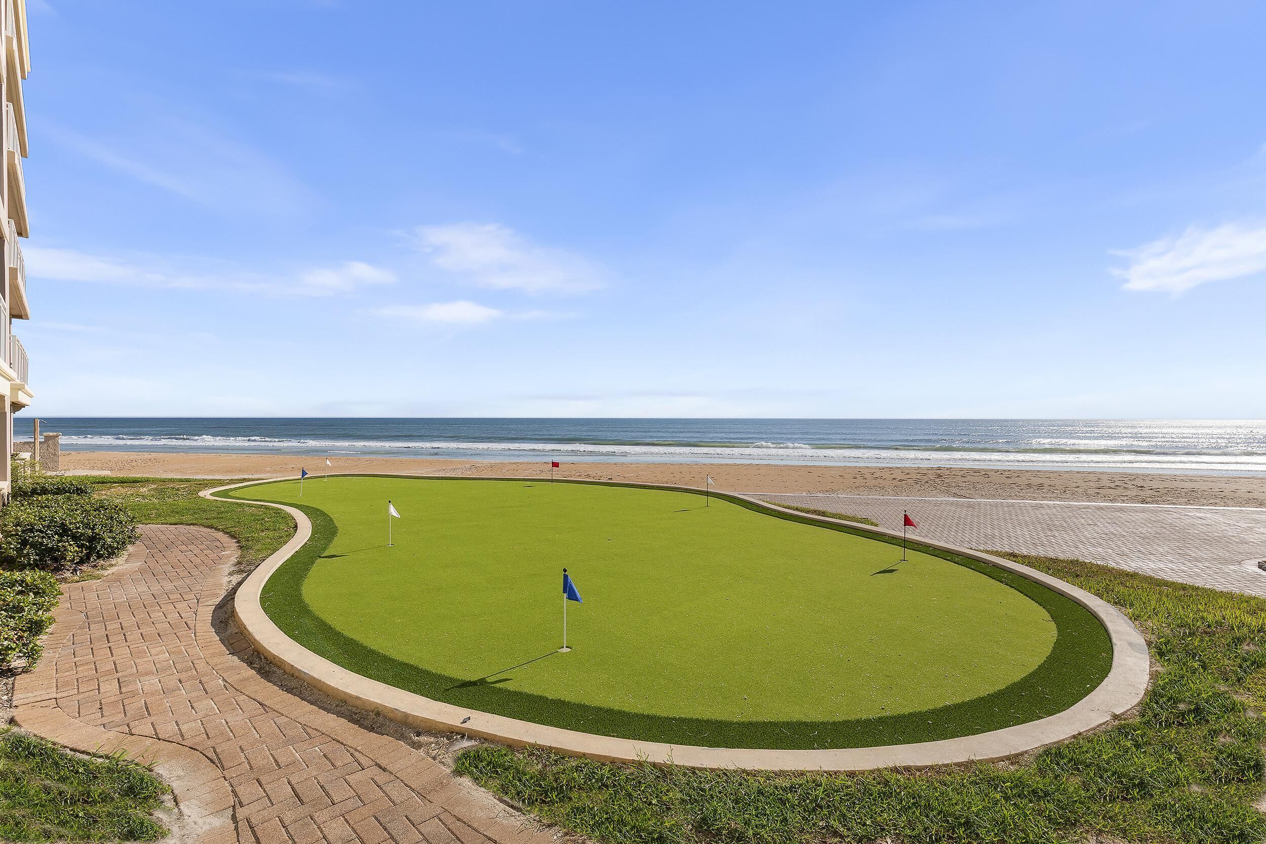 A golf course with a view of the beach and ocean.