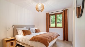 Ein Schlafzimmer mit Bett, Nachttisch und einem Fenster mit Vorhängen.