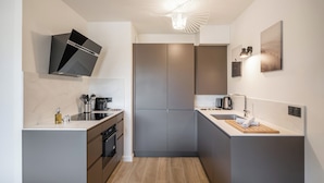 A modern kitchen with a built-in oven, a microwave, and a coffee maker.