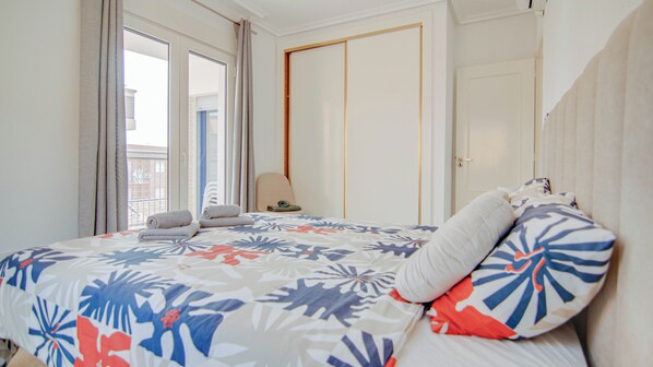 A hotel room with a bed, a chair, and a door. - 50m from the beach | Calle San Enrique 3-2 (Los Alcázares)