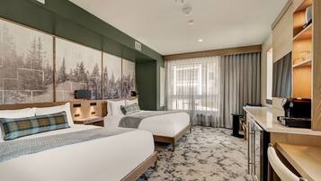 A hotel room with two beds, a large painting, a television, and a desk.