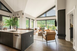 A modern kitchen with a central island, large windows, and a view of a mountainous landscape. - Keystone Escape | Luxe Penthouse w/ Pool + Views (Keystone)
