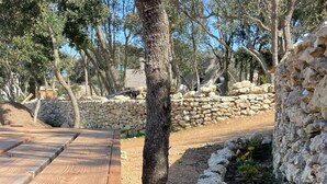 Un banco de madera con un muro de piedra y un jardín con rocas y plantas.