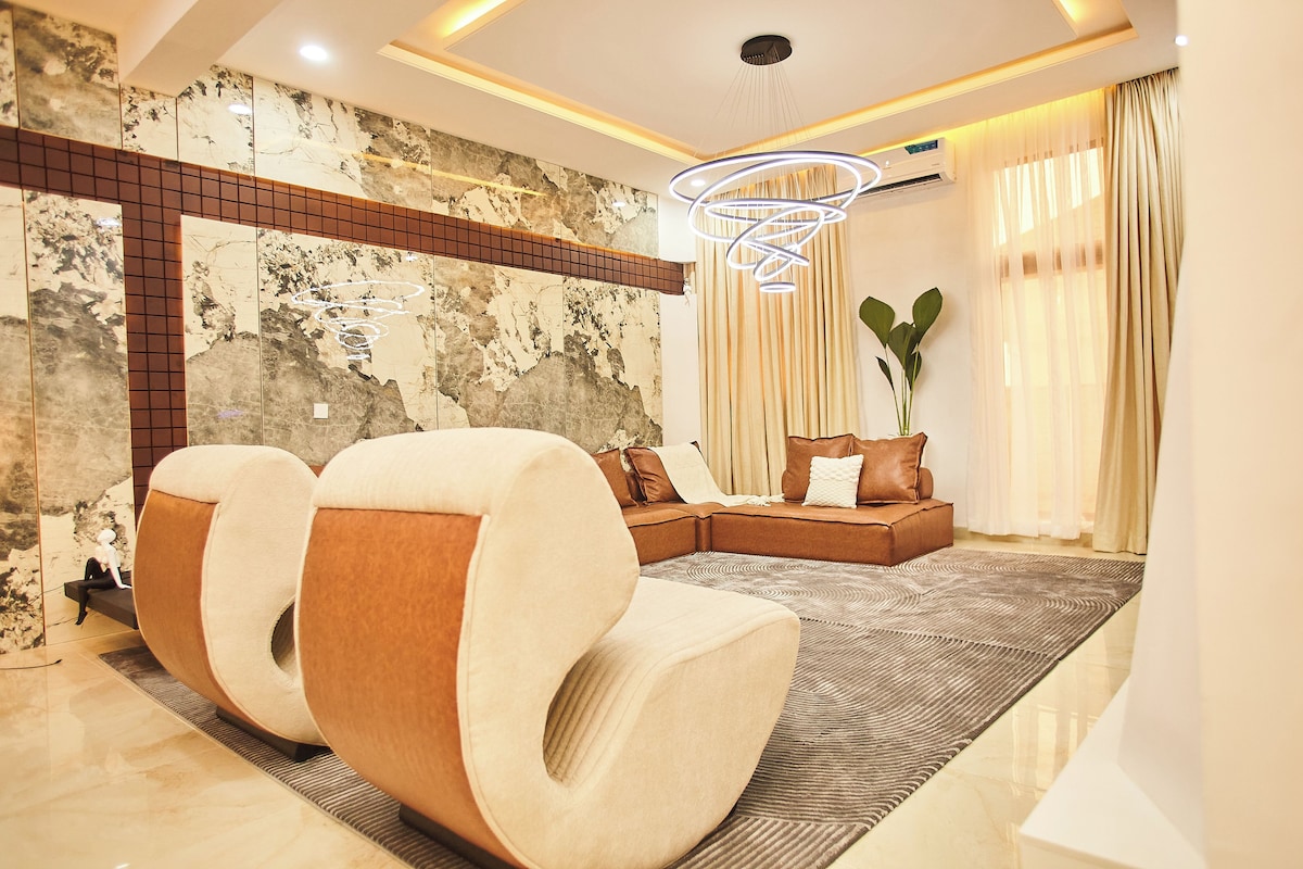 Una sala moderna con un sofá modular, una alfombra grande y una decoración de pared.