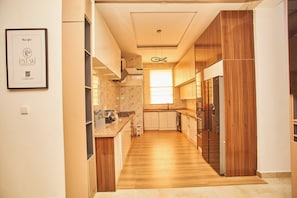 Una cocina moderna con armarios de madera, un salpicadero de mármol y un horno empotrado.