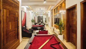 A modern living room with a pool table, a sofa, and a dining area. - Midak Mews 2 Oceanview Luxury Apartments (Lekki)