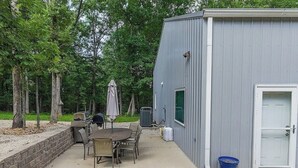 A patio with outdoor furniture, a grill, and a shed with a door and window. - Barndo in the Rocky Mt Woods (Rocky Mount)