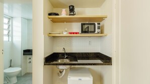 A compact kitchen with a microwave, coffee maker, and a sink. - Studio With Prime Location in POA - Els0606 (Porto Alegre)