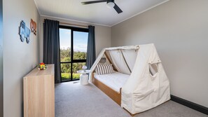 A bedroom with a bed, a desk, and a window with curtains. - Capeviews on Higgins with separate Studio (Rye)