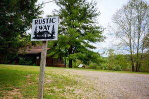 A rustic way sign with a house and trees in the background. - Welcome to Rustic Way! (McArthur)