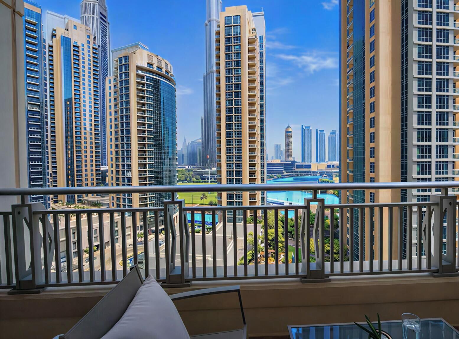 Uma varanda com vista para edifícios altos e uma piscina.