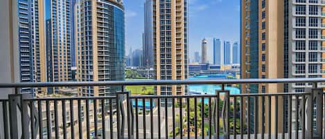 A balcony with a view of high-rise buildings and a pool.