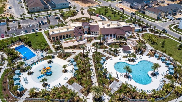 Une vue aérienne d’un complexe hôtelier doté de deux grandes piscines, d’un parc aquatique et de nombreuses installations, notamment des espaces de détente et des jardins aménagés.