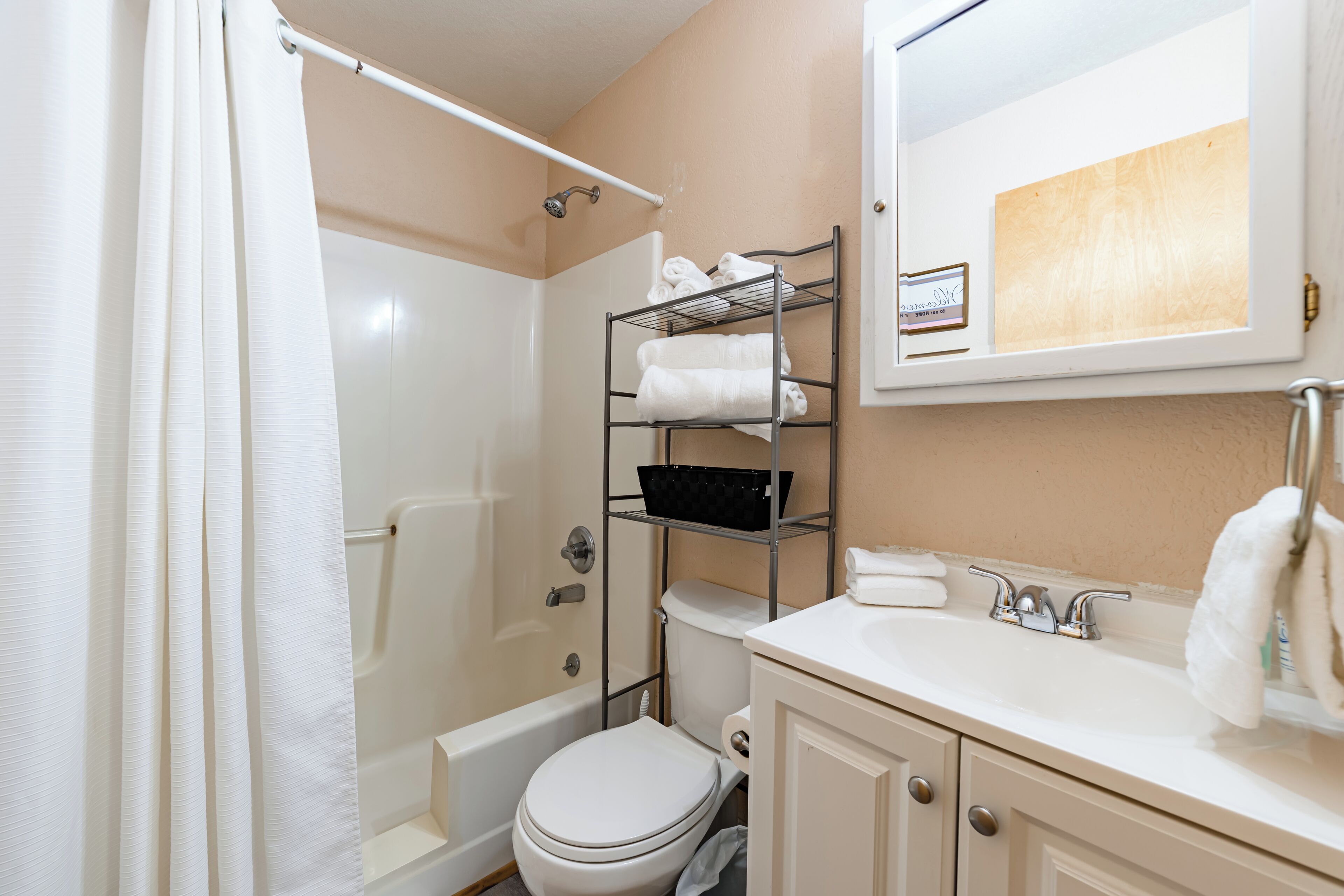 A bathroom with a shower, toilet, and sink.